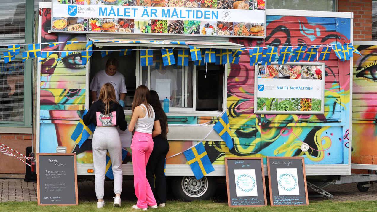 Elever serveras mat från en food truck.