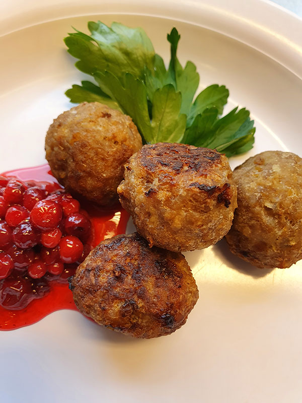 Köttbullar med lingonsylt, på en ljus tallrik