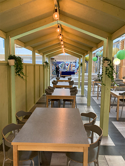 Måltidsmiljö under ett lågt tak i skolrestaurangen.