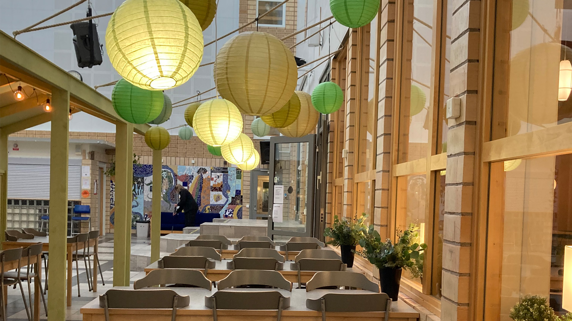 Måltidsmiljö med runda rislampor i taket.