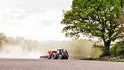 Traktor som sår, på en åker. 