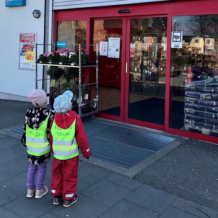Förskolebarn utanför matbutik.