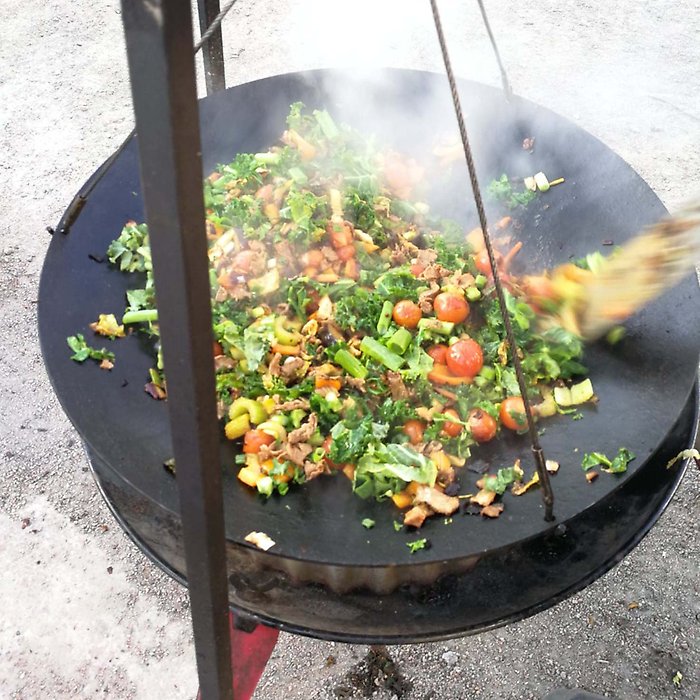 Matlagning ute på plåt över öppen eld.