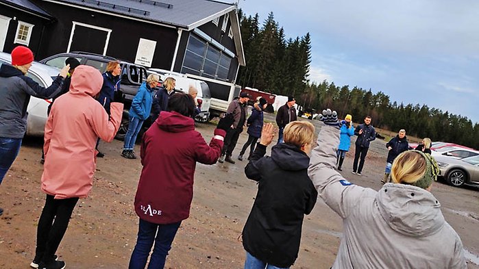 Människor samlade på gårdsplanen utanför en ladugård.