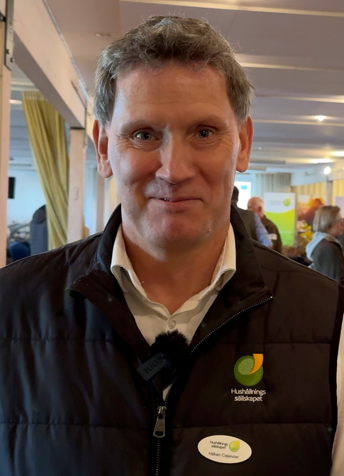 Håkan Cajander har svart väst, mörkt hår och hushållningssällskapets logga på västen