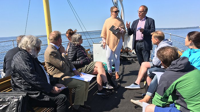 Michael Cornell pratar inför deltagarna under ångbåtsturen på Vättern.