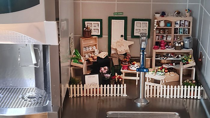Kockmusens bistro med minatyrer av maträtter, köksredskap och inredning.